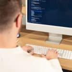photo d'un designer web en train de coder sur son ordinateur