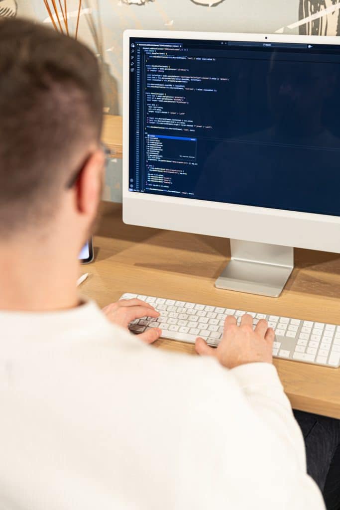 photo d'un designer web en train de coder sur son ordinateur