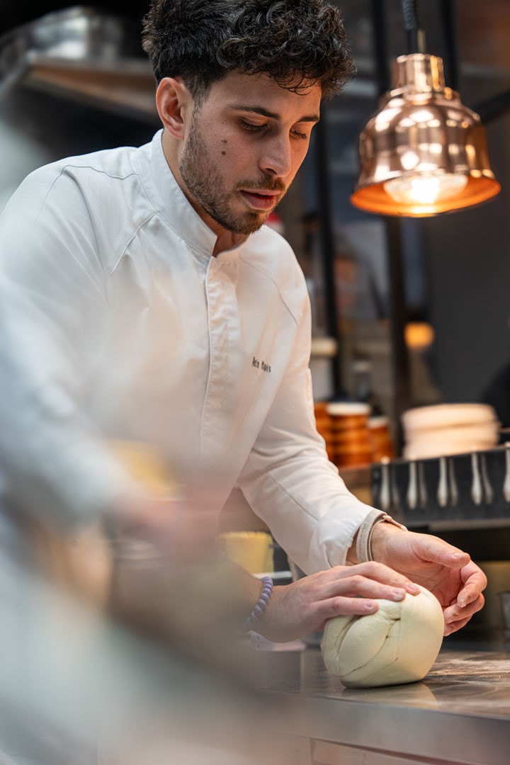 portrait du chef Quentin Maufrais en train de pétrir une pâte