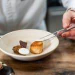 photo culinaire main qui dresse le plat