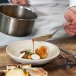 photo culinaire geste cuisine main qui ajoute de la sauce