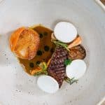 photo culinaire plat vu de dessus avec une noix de saint Jacques et un cèpe