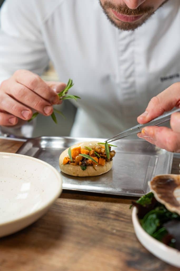 photo culinaire main en train de dresser un plat