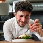 photo culinaire du chef Quentin Maufrais souriant en train de dresser un plat
