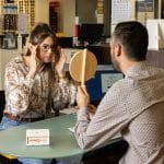 photo d'un opticien qui montre à sa cliente son reflet avec des lunettes de vue