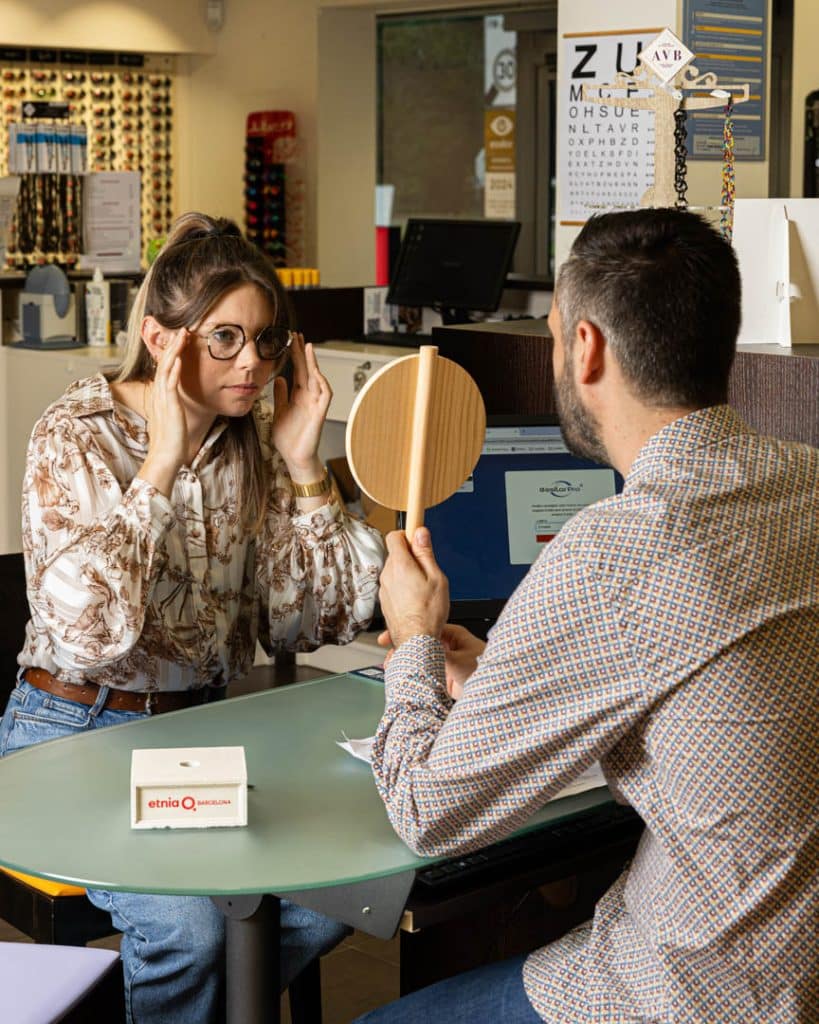 photo d'un opticien qui montre à sa cliente son reflet avec des lunettes de vue