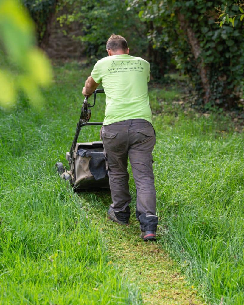 photo d'un jardinier qui tond la pelouse