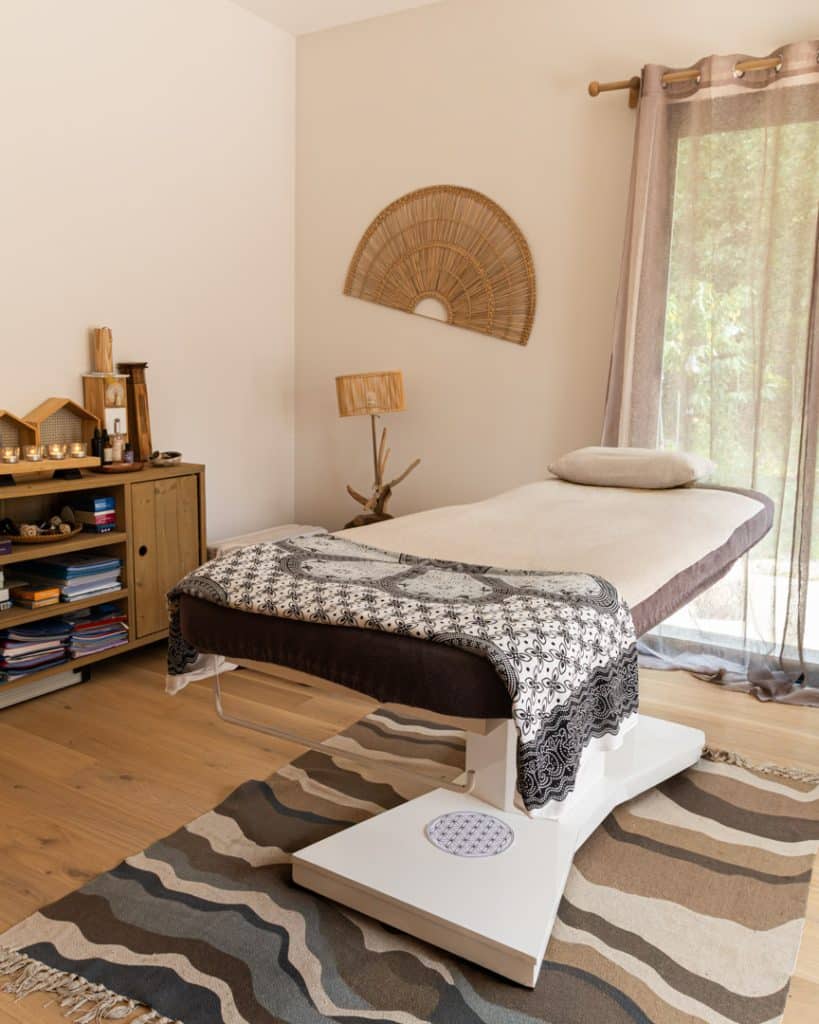 photo d'une salle de soin avec un lit de massage et une décoration zen